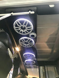 Black soundbar with white charcoal grilles and white LED ring lights from the RGB LED Ring Light Kit installed in a Jeep, part of a custom audio system.