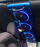 Blue chrome soundbar with large blue LED ring lights installed in a Jeep, part of a custom Jeep audio system.