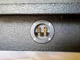 Close-up view of BRP push terminals on the underseat subwoofer enclosure, designed for secure and efficient speaker wire connections