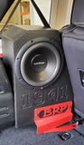 Rockford Fosgate Prime "R2D2" - Side angle view of a single BRP JL/JLU subwoofer installed in the rear wheel well of a Jeep Wrangler, secured with a red BRP stabilizer plate in the subwoofer box