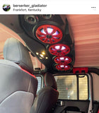 Black soundbar with red charcoal grilles covering the speakers and white lighting controlled by the Kicker RGB LED Controller, part of a custom Jeep audio system.
