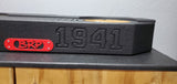 Close-up view of the BRP JT Gladiator underseat subwoofer enclosure, featuring an engraved '1941' and a red BRP metal plate screwed into the enclosure for added durability